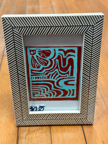 Blue/red linocut art in frame